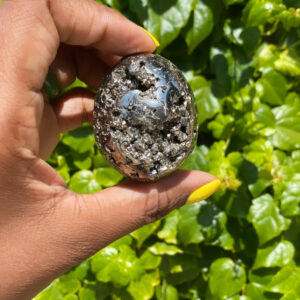 Hand holding a pyrite crystal egg.