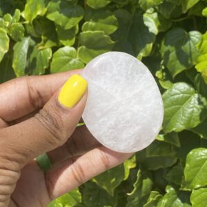 White selenite palm stone held in hand.