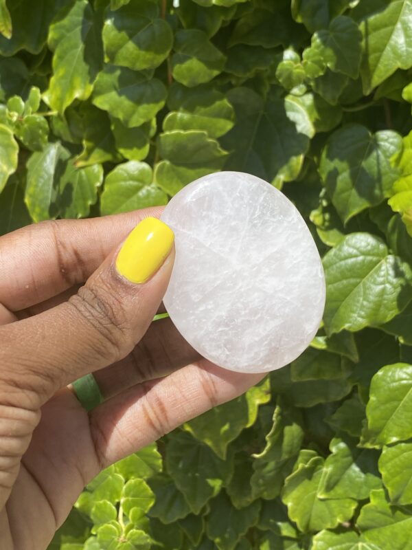 White selenite palm stone held in hand.