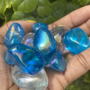 Hand holding blue and white iridescent stones.