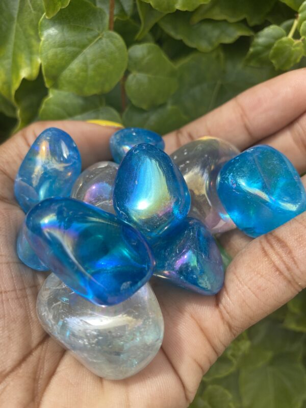 Hand holding blue and white iridescent stones.