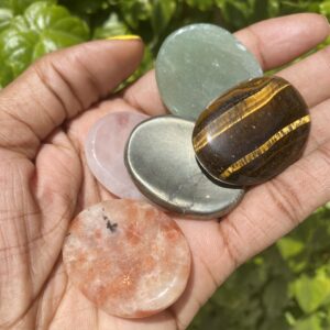 Hand holding assorted polished stones.