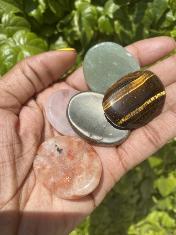 Hand holding assorted polished stones.