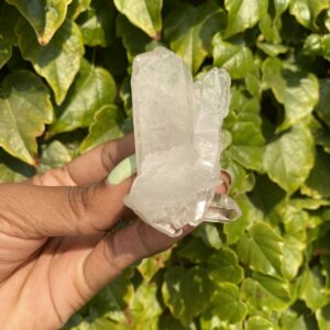 Clear quartz crystal held in hand.