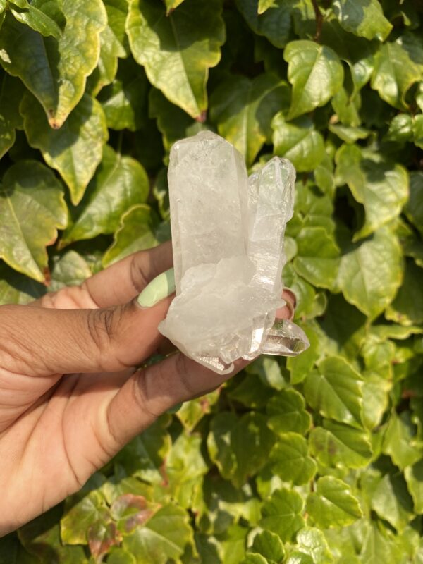 Clear quartz crystal held in hand.