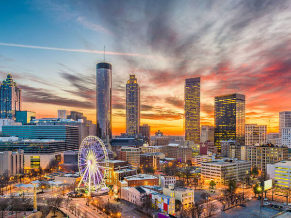 Atlanta skyline at sunset with Ferris wheel.