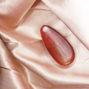 Red gemstone on pink satin fabric.