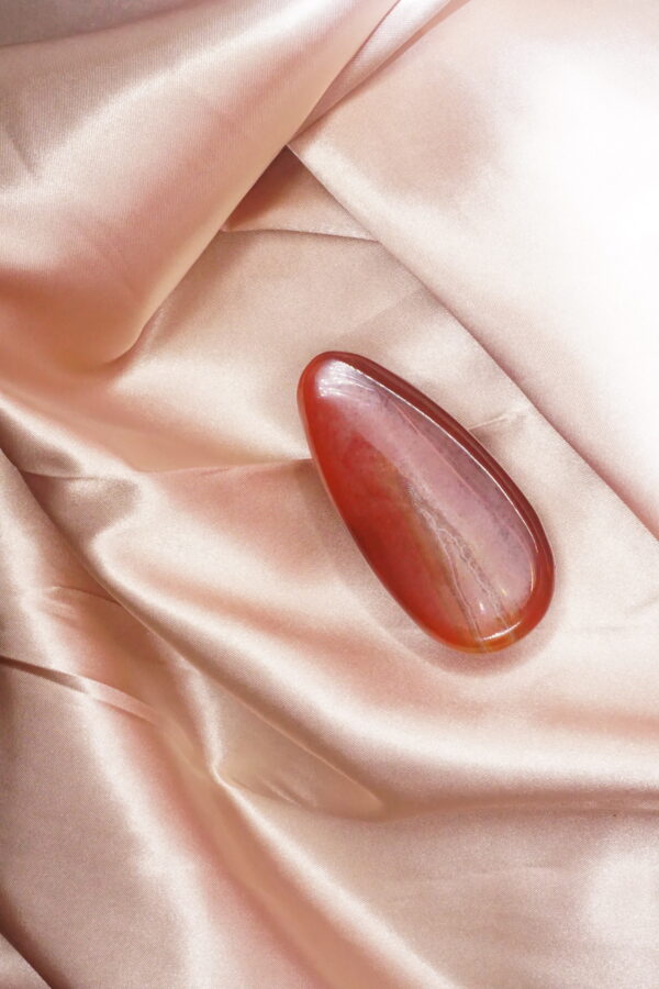 Red gemstone on pink satin fabric.