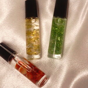 Three glitter roll-on bottles on fabric.