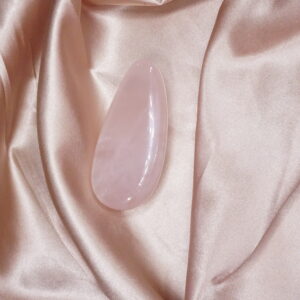 Pink rose quartz on satin fabric.