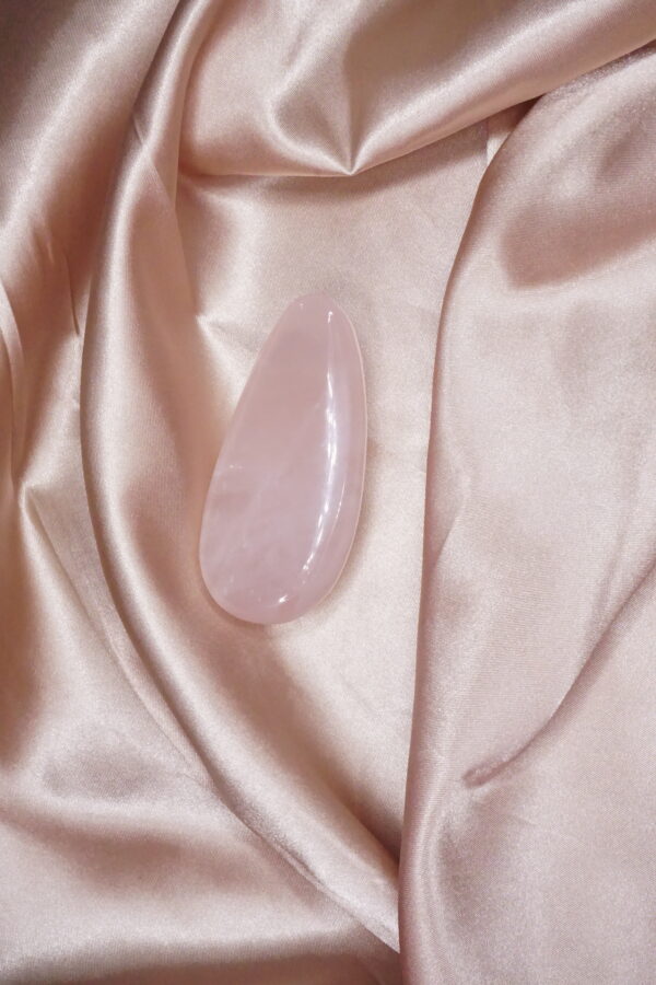 Pink rose quartz on satin fabric.