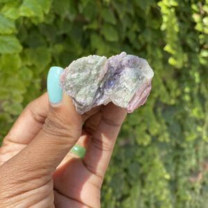 Green and pink tourmaline crystal in hand.