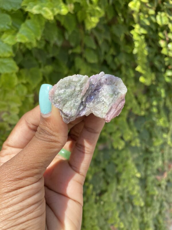 Green and pink tourmaline crystal in hand.