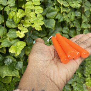 Three orange candle sticks in a hand.