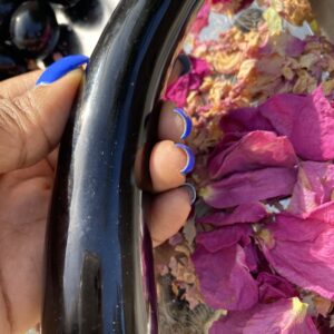 Black obsidian wand with rose petals.