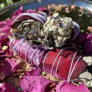 White sage smudge stick with rose petals.