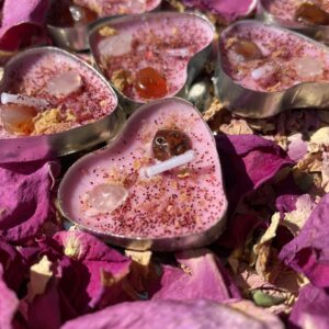 Heart-shaped candles with crystals and rose petals.