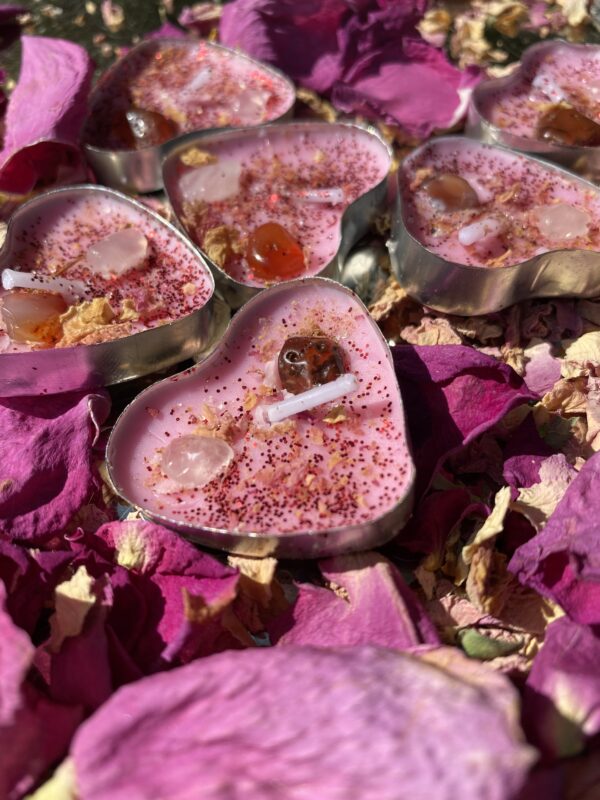 Heart-shaped candles with crystals and rose petals.