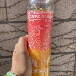 Red and yellow candle with Spanish text.