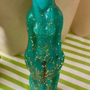 Teal glitter candle shaped like a woman.