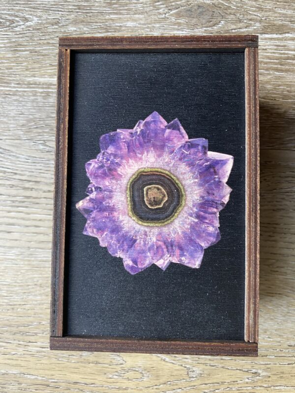 Amethyst crystal in a wooden frame.