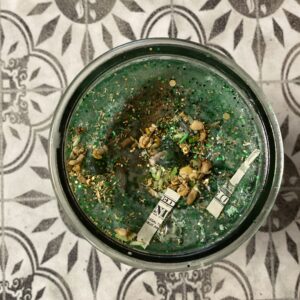 A bowl of green food on top of the floor.