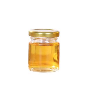 A jar of honey with gold lid on white background.