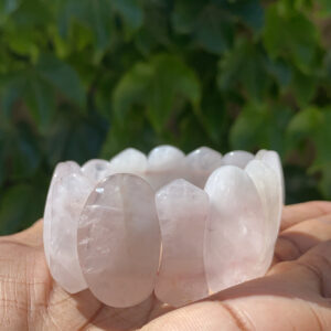 A person holding a bowl of rose quartz