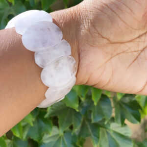 A person wearing a bracelet with white beads