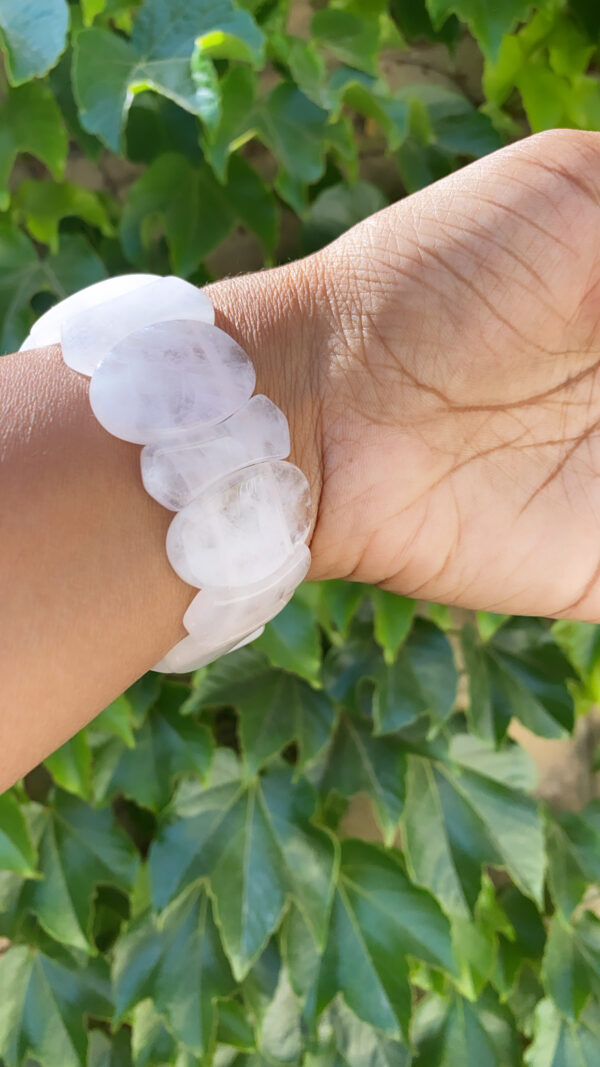 A person wearing a bracelet with white beads