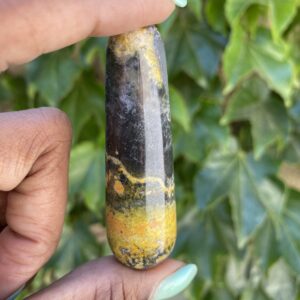 A person holding onto a stone with yellow and black paint.