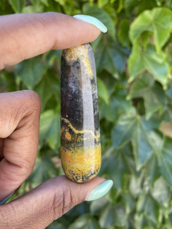 A person holding onto a stone with yellow and black paint.