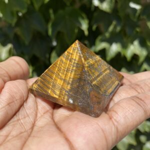 A person holding a small pyramid in their hand.