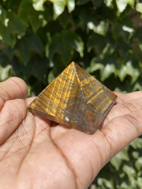 A person holding a small pyramid in their hand.