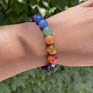 A person wearing a bracelet with different colored beads.