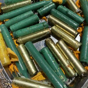 A bunch of green and yellow bullets are in the bin