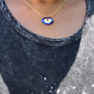 A woman wearing an evil eye necklace.