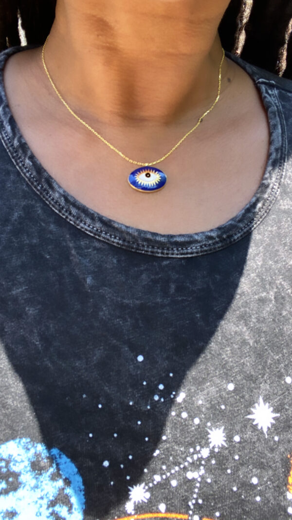 A woman wearing an evil eye necklace.