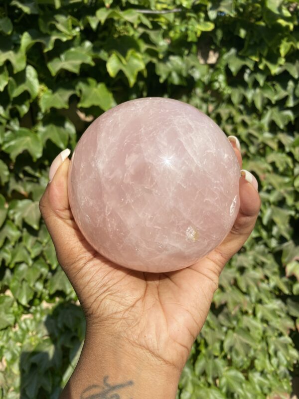 A person holding a large pink crystal ball.