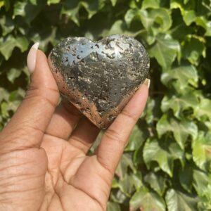 A person holding onto a heart shaped rock