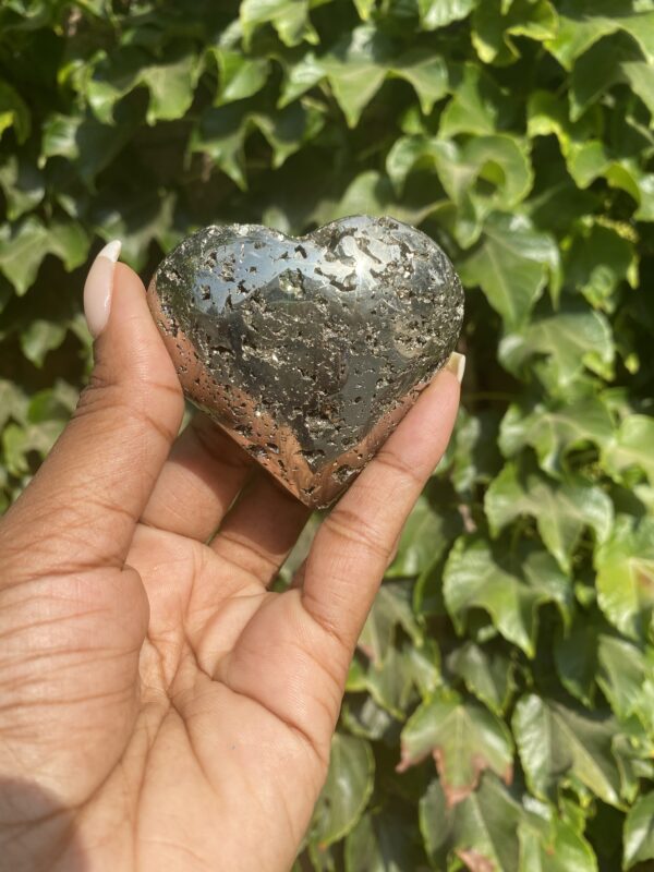 A person holding onto a heart shaped rock