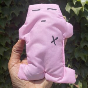 A person holding a pink stuffed animal in their hand.