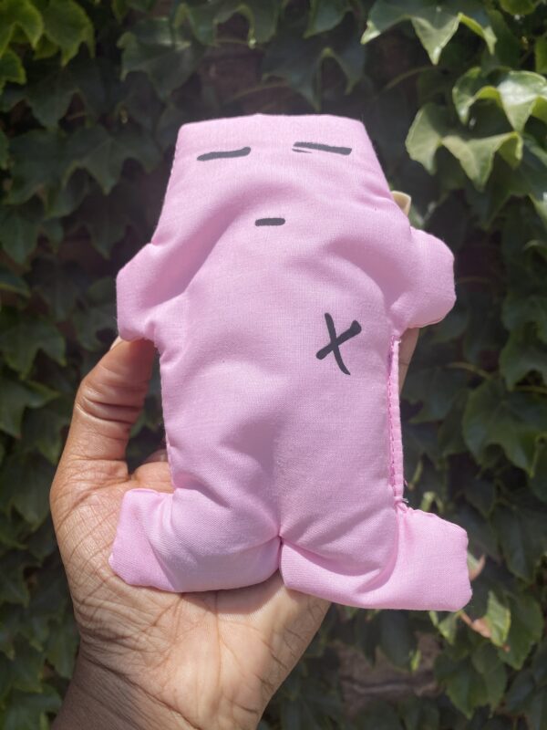 A person holding a pink stuffed animal in their hand.