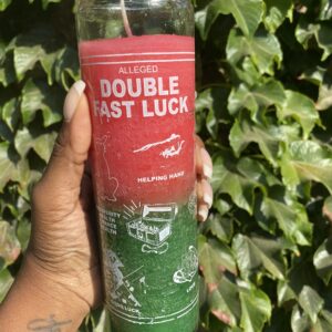 A person holding onto a candle that says double fast luck