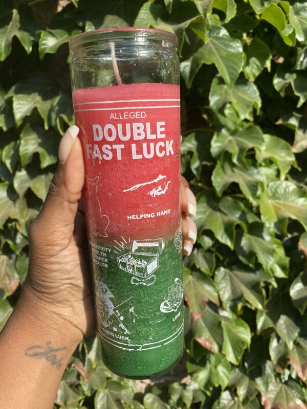 A person holding onto a candle that says double fast luck