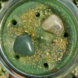 A cup of green liquid with rocks inside.