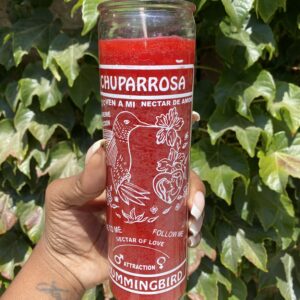 A person holding onto a candle with the words " chuparrosa " on it.