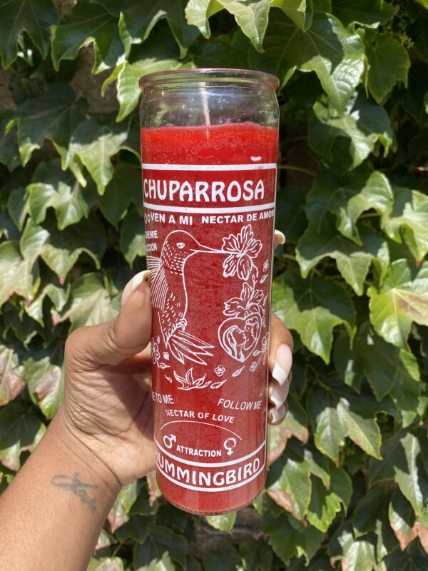 A person holding onto a candle with the words " chuparrosa " on it.