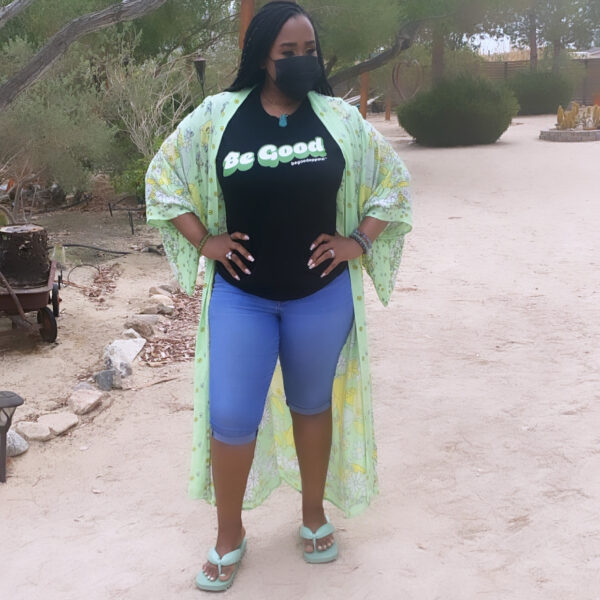 A woman standing on the beach wearing blue shorts and sandals.