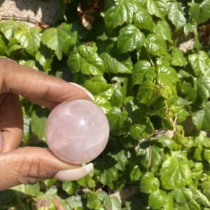 A person holding a pink stone in their hand.